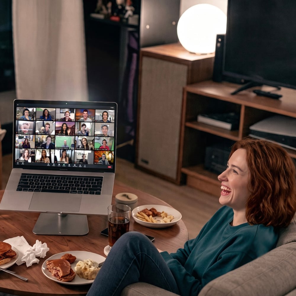 A guest laughing on a video call, the rest of the group on screen beside her